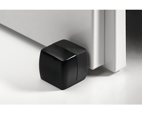 Oprirea neagră din plastic pentru ușă lângă o ușă albă