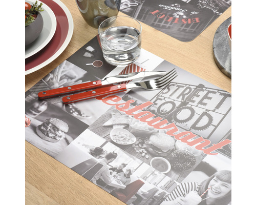 Decor de masă cu suport de farfurie, tacâmuri și pahar pe o masă din lemn