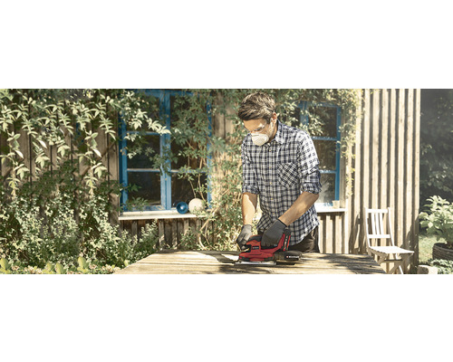 Un bărbat șlefuiește lemn cu o șlefuitoare electrică în aer liber