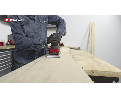 O persoană șlefuiește lemn cu un șlefuitor vibrator Einhell.