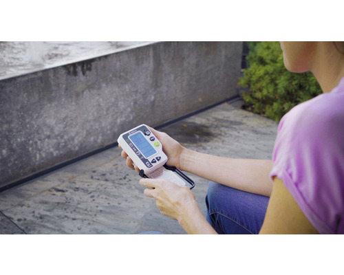 O persoană ține în mână un higrometru de sol Gardena