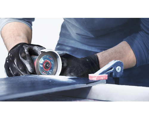 Artizan care taie o țiglă cu o mașină de șlefuit