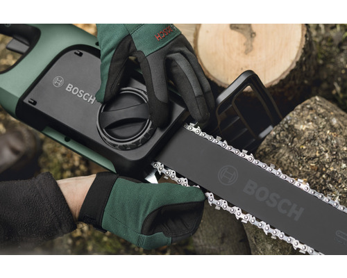 Logo Bosch pe un motoferăstrău cu acumulatori, ținut de două mâini cu mănuși
