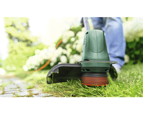 Mașină de tuns iarba utilizată pe un gazon.