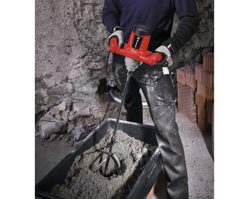 O persoană folosește un mixer de mortar pentru a amesteca mortarul într-o găleată.