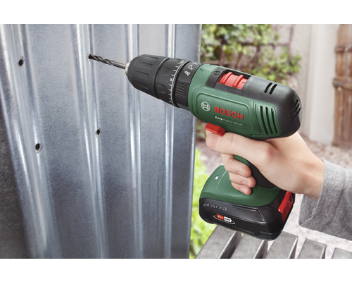 Mașină de găurit și înșurubat cu acumulator care găurește o tablă metalică