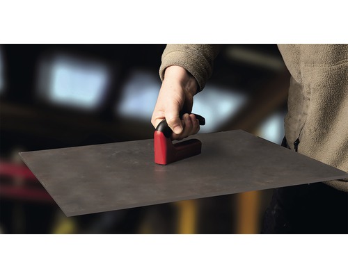 O persoană ține un tăietor de faianță pentru a tăia faianța