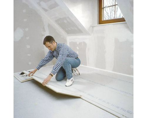 Bărbat care așază elemente de șapă uscată în mansardă.