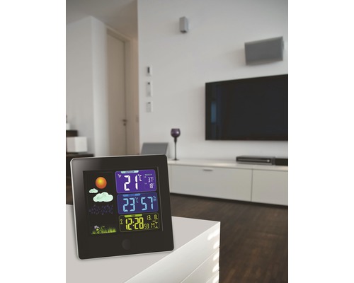 Stație meteo cu afișaj pentru temperatură, umiditate și oră într-un living modern