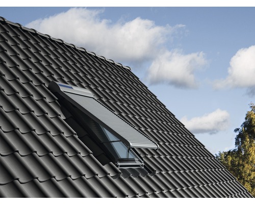 Fereastră de mansardă cu jaluzea închisă pe un acoperiș de casă