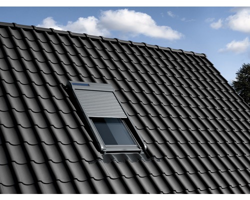 Fereastră de mansardă cu oblon închis într-un acoperiș de țiglă