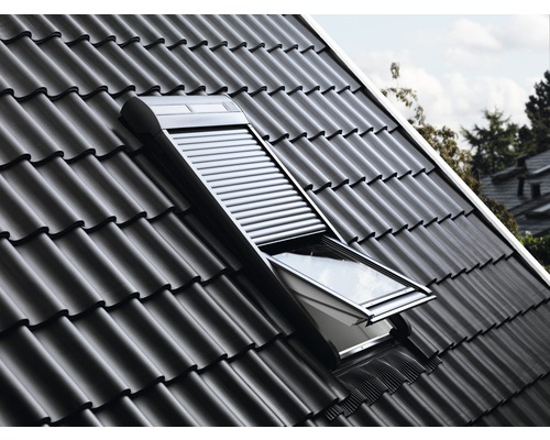 Fereastră de mansardă cu rulou într-un acoperiș de țiglă