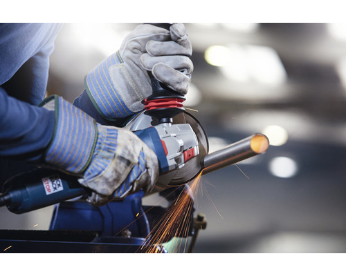 Persoană șlefuind o țeavă metalică cu un polizor unghiular într-o menghină