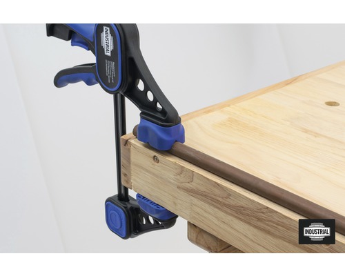 Clește cu bară fixând o piesă de lucru pe un banc de lucru.