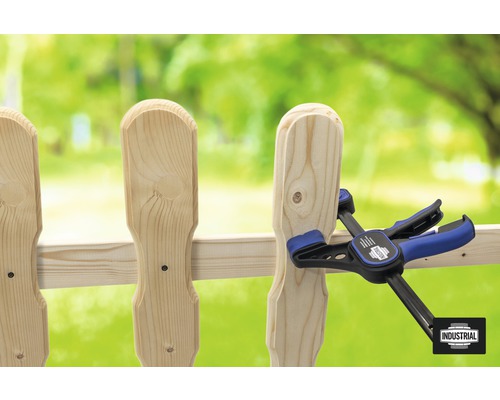 Gardul din lemn este fixat cu o menghină.