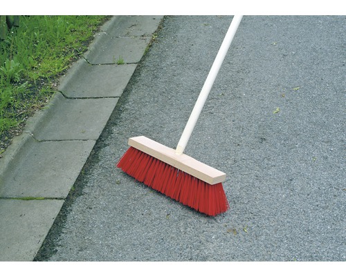 Mătură cu coadă de lemn pe asfalt