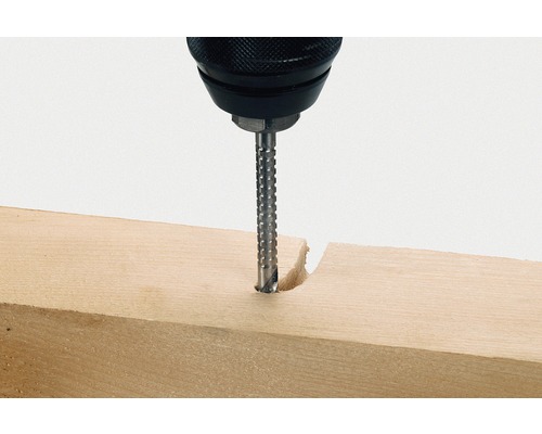 O mașină de găurit face o gaură într-o bucată de lemn.