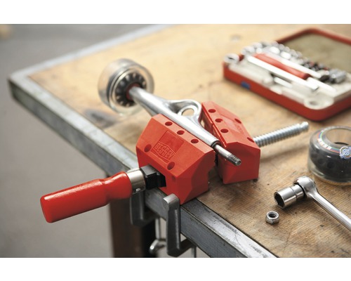 Axă de skateboard prinsă în menghină pe un banc de lucru