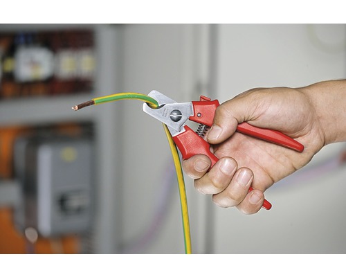 O persoană taie un cablu de împământare cu un clește de cablu