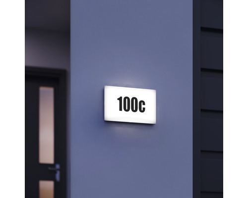 Placă de număr de casă iluminată cu numărul 100c pe un perete