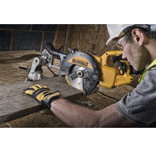 Un muncitor folosește un ferăstrău circular DeWalt pentru a tăia o bucată de lemn.