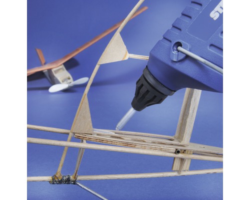 Pistol de lipit cu topire la cald care lipeste un model de avion