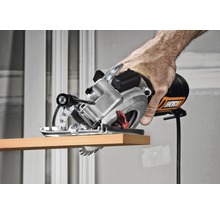 Mână care folosește un ferăstrău circular manual Worx pentru a tăia o bucată de lemn