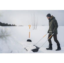 Bărbat care curăță zăpada cu o lopată de zăpadă în timpul iernii