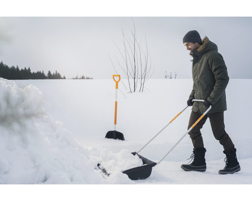 Bărbat care curăță zăpada cu o lopată de zăpadă în timpul iernii