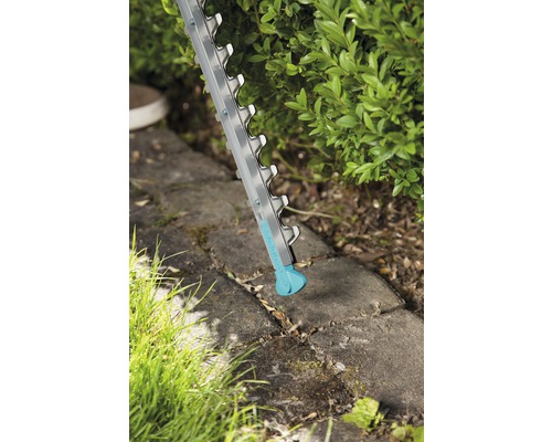 Foarfecă de tuns gard viu în acțiune la tăierea unui gard viu