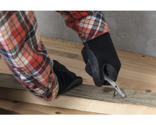 O persoană scoate un cui dintr-o scândură de lemn cu o scoate cuie