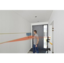 Bărbat folosind un laser liniar pentru a picta un perete