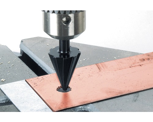 Debavurator pe o mașină de găurit care debavurează o placă metalică