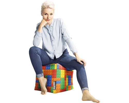 Femeie așezată pe un taburet cu design de blocuri de construcție