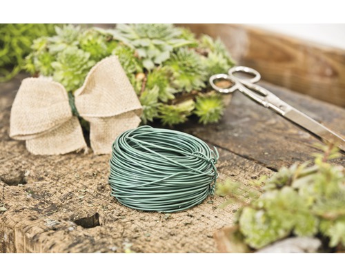 Sârmă de florărie, foarfece, fundă și plante pe o masă