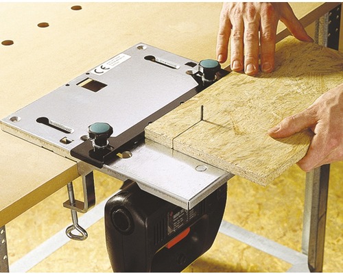 Persoană care taie lemn cu un ferăstrău vertical și o masă pentru ferăstrău vertical