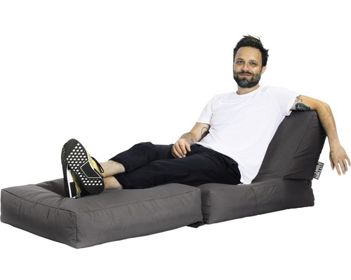 Bărbat relaxându-se pe un sac de fasole gri cu suport pentru picioare