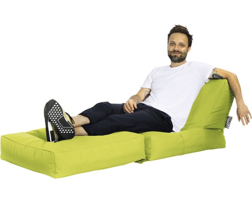 Bărbat relaxându-se pe un puf luminos cu suport pentru picioare