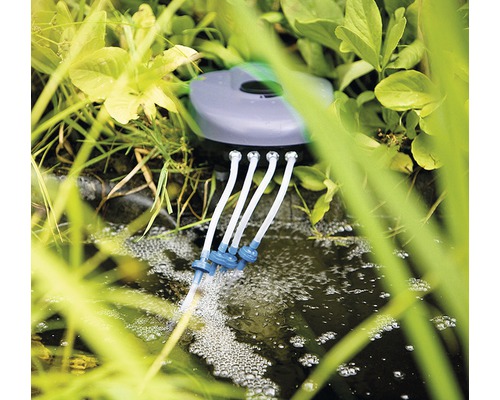 Aerator de iaz în funcțiune, înconjurat de plante