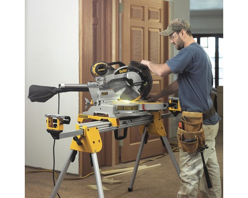 Un ferăstrău circular cu un muncitor pe un șantier care taie lemne.