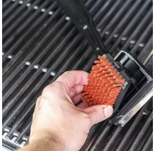 Curățarea unei suprafețe de grătar cu o perie de grătar