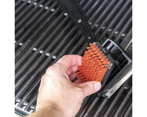 Curățarea unei suprafețe de grătar cu o perie de grătar