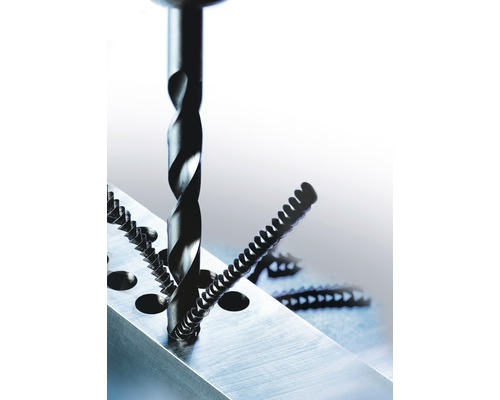 Burghiu elicoidal găurește un bloc metalic, șuruburi așezate alături