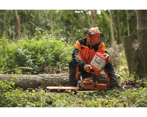 Scenă de pădure cu muncitor forestier, drujbă și combustibil special Aspen