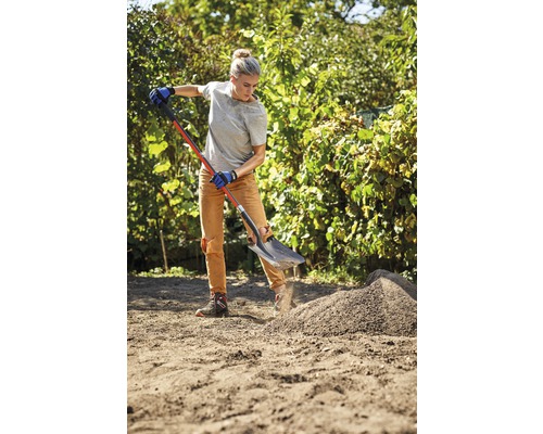 Femeie lucrează cu o sapă în grădină