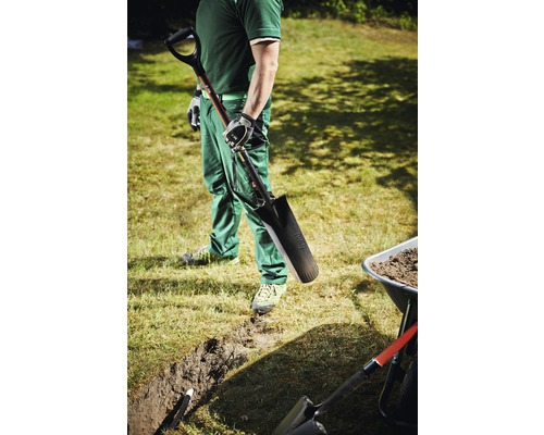 Bărbat cu hârleț, șanț și roabă în grădină