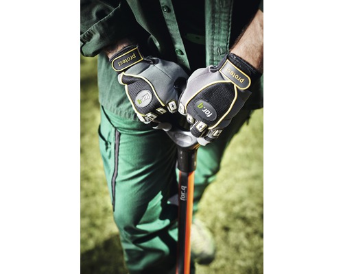 O persoană în haine de lucru ține un hârleț cu mănuși de grădină.