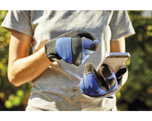 O persoană cu mănuși de lucru folosește un smartphone.