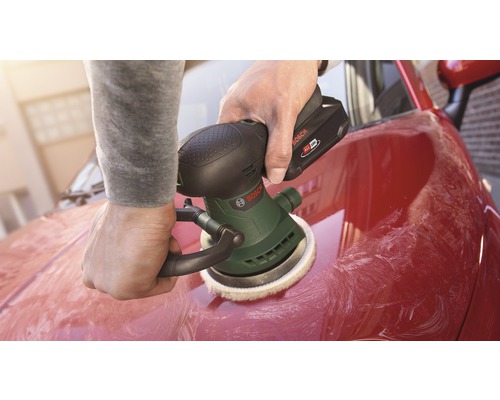 O persoană lustruiește o mașină roșie cu o mașină de lustruit cu acumulator Bosch