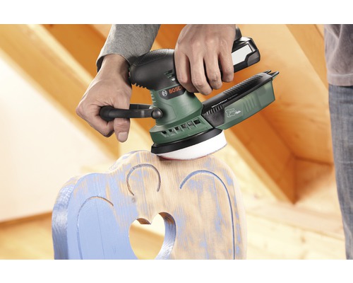 Bărbat șlefuind un scaun din lemn cu o șlefuitoare excentrică Bosch